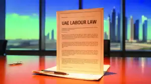 UAE Labour Law document on a desk with Dubai skyline — GCC jobs and Gulf employment regulations.